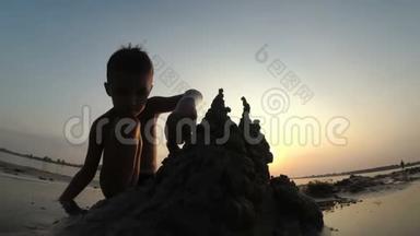海滩儿童<strong>剪影</strong>：在日落时建造沙堡